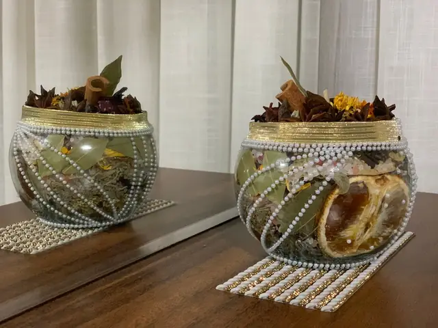 Amuletos energéticos em vasos de vidro com ervas, canela e folha de louro, decorados com fita de strass