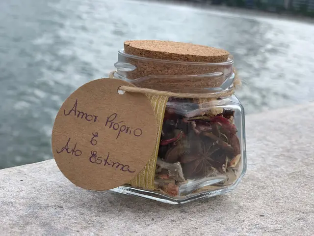 Pote de vidro com tampa de cortiça e ervas secas, etiqueta “Amor-próprio e Autoestima”